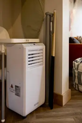 a small refrigerator sitting next to a table with a baseball bat at Luxury Stay, City Walk, Pool Table & Air Hockey, Garden, Parking, Business & Families - Oakview in Colchester