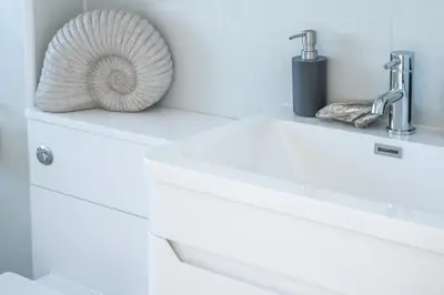 a white bathroom sink with a fan on top of it at 19 Undercliffe in Felixstowe