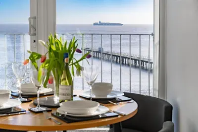 a dining table with a view of the ocean at 19 Undercliffe in Felixstowe