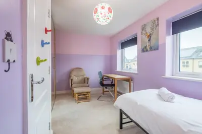 a bedroom with purple walls and a bed and a desk at Modern and Comfy 3 bed Cambridge House in Cambridge