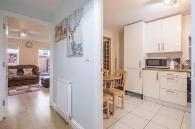 a kitchen and living room with a table and a microwave at Modern and Comfy 3 bed Cambridge House in Cambridge