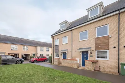 a row of brick houses with cars parked in a driveway at Modern and Comfy 3 bed Cambridge House in Cambridge