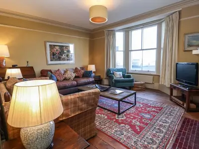 a living room with a couch and a tv at 11a Market Cross Place in Aldeburgh