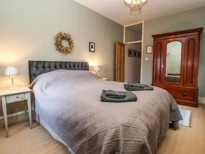 a bedroom with a large bed with two towels on it at 11a Market Cross Place in Aldeburgh