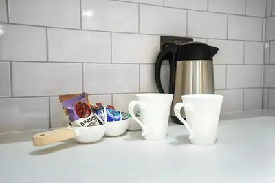 a counter top with cups and a coffee pot at Lucas in Sudbury