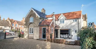 an old house with a courtyard in front of it at The Lodge, Saxmundham in Saxmundham