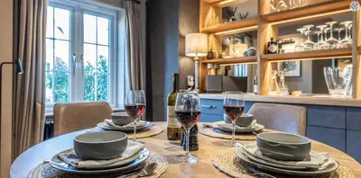 a table with two glasses of wine on it at The Lodge, Saxmundham in Saxmundham