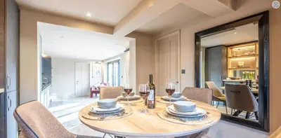 a dining room with a table and chairs and a mirror at The Lodge, Saxmundham in Saxmundham