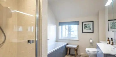 a bathroom with a tub and a toilet and a sink at The Lodge, Saxmundham in Saxmundham