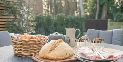 a table with bread and a basket of bread at The Lodge, Saxmundham in Saxmundham