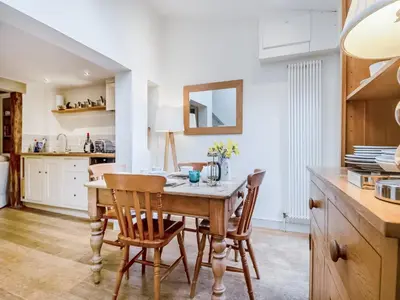 a kitchen and dining room with a wooden table and chairs at September Cottage in Wenhaston