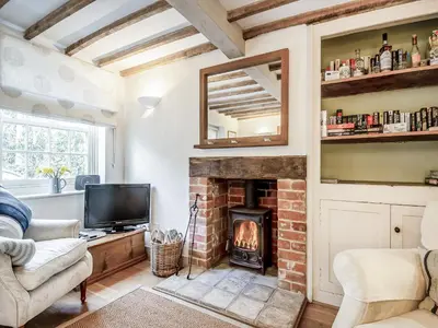 a living room with a fireplace and a tv at September Cottage in Wenhaston