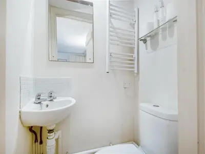 a white bathroom with a sink and a toilet at September Cottage in Wenhaston