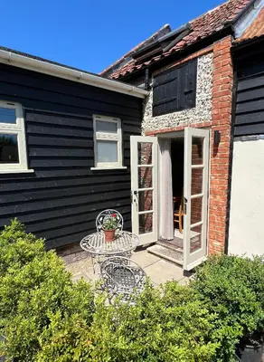 a patio with a table in front of a house at The Old Stable at Manor House, Middleton in Middleton