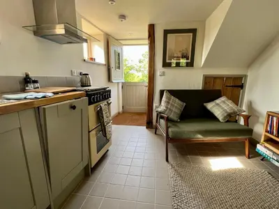 a kitchen with a stove and a couch in it at The Old Stable at Manor House, Middleton in Middleton