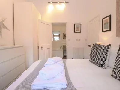 a bedroom with a bed with white sheets at The Nook in Halesworth