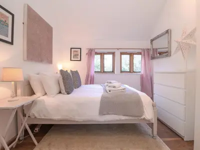 a bedroom with a bed with a desk and a window at The Nook in Halesworth
