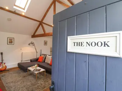 a blue wall in a living room with a couch at The Nook in Halesworth