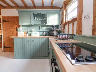 a kitchen with green cabinets and a sink at Twosome in Halesworth