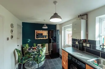a kitchen with a table and a refrigerator at 2 Bedroom Peaceful Home, Colchester in Mile End