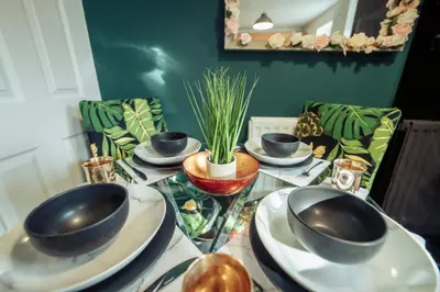 a table with plates and bowls on top of it at 2 Bedroom Peaceful Home, Colchester in Mile End