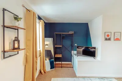 a room with a blue wall and a tv at 2 Bedroom Peaceful Home, Colchester in Mile End