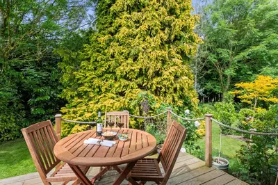 a wooden table and chairs on a wooden deck at Barn studio in Long Melford in Long Melford