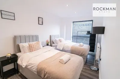 a bedroom with two beds and a window at Royal Oak Apartments 3 - Secure Parking - Perfect for Contractors - 2 Bedroom - 2 Bathroom - Fast Wi-fi - Long Term Stays - in Brentwood