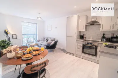 a kitchen and living room with a table with food on it at Royal Oak Apartments 3 - Secure Parking - Perfect for Contractors - 2 Bedroom - 2 Bathroom - Fast Wi-fi - Long Term Stays - in Brentwood