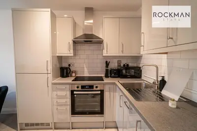 a kitchen with white cabinets and a stove top oven at Royal Oak Apartments 3 - Secure Parking - Perfect for Contractors - 2 Bedroom - 2 Bathroom - Fast Wi-fi - Long Term Stays - in Brentwood
