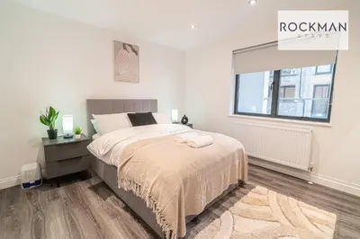 a white bedroom with a bed and a window at Royal Oak Apartments 3 - Secure Parking - Perfect for Contractors - 2 Bedroom - 2 Bathroom - Fast Wi-fi - Long Term Stays - in Brentwood