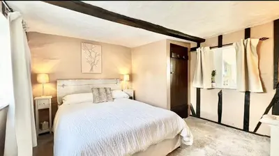 a bedroom with a white bed and two windows at Chelmsford Cottage Free Parking Fab Garden in Great Waltham