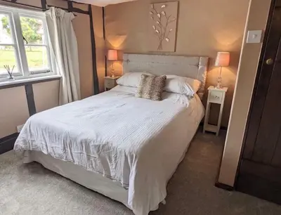 a bedroom with a large white bed with two lamps at Chelmsford Cottage Free Parking Fab Garden in Great Waltham