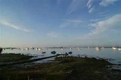 a large body of water with boats and a bridge at Secret Mersea Retreat - a stroll from the anchorage! in West Mersea