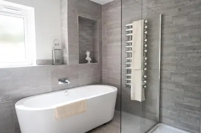 a bathroom with a white tub and a glass shower at Secret Mersea Retreat - a stroll from the anchorage! in West Mersea