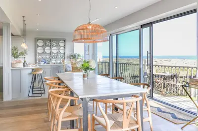 a kitchen and dining room with a table and chairs at Spinneys Beachfront home, Indoor Pool UK-Vacations in Thorpeness