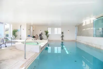 a large swimming pool with a tub and a sink at Spinneys Beachfront home, Indoor Pool UK-Vacations in Thorpeness