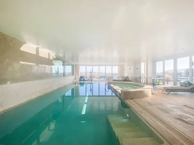a large swimming pool in a building at Spinneys Beachfront home, Indoor Pool UK-Vacations in Thorpeness