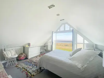 a bedroom with a bed and a large window at Spinneys Beachfront home, Indoor Pool UK-Vacations in Thorpeness
