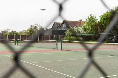 a tennis court seen through a net at Stylish and homely 1 bed Edwardian Coach House in Colchester