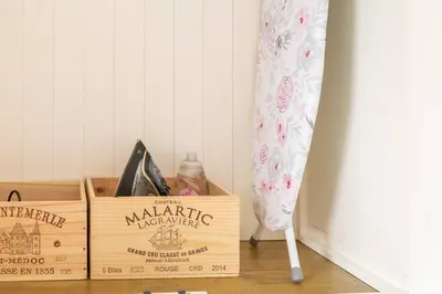 a wooden box with a bottle of marmitemite next to a curtain at Stylish and homely 1 bed Edwardian Coach House in Colchester