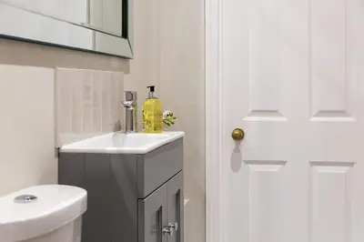 a white bathroom with a sink and a white toilet at Stylish and homely 1 bed Edwardian Coach House in Colchester