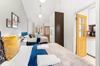 a bedroom with two beds and a couch at Boutique Cambridgeshire Gem in Fulbourn