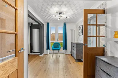 a hallway with a blue chair and a door at Boutique Cambridgeshire Gem in Fulbourn