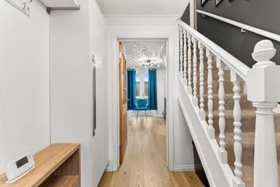 a hallway with white walls and stairs with blue accents at Boutique Cambridgeshire Gem in Fulbourn