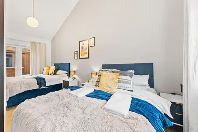 two beds in a room with white and blue at Boutique Cambridgeshire Gem in Fulbourn