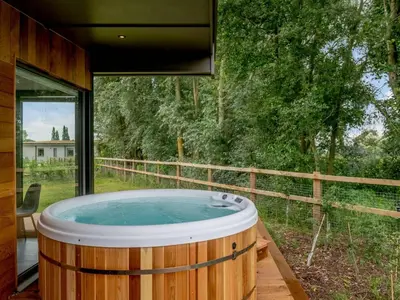 a large wooden tub sitting on a deck next to a window at 2 Bed in Colchester oc-82398 in East Bergholt