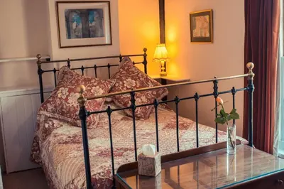 a bedroom with a bed with a glass table at Toad Hall in Swilland