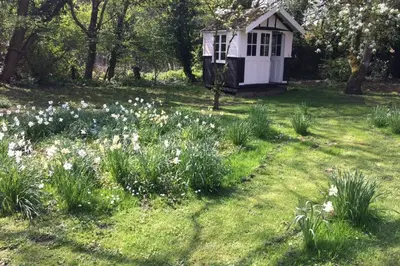a garden with a small white dog house at Toad Hall in Swilland