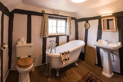 a bathroom with a tub and a toilet and a sink at Toad Hall in Swilland